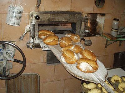 Pan de payés de medio kilo saliendo del horno de leña